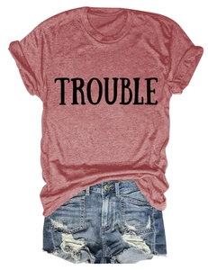 Dettaglio di una maglietta a girocollo consumata con stampa TROUBLE e shorts in denim rotti