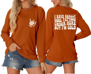 Front and back detail of orange crewneck sweatshirt with white tattoo themed typography