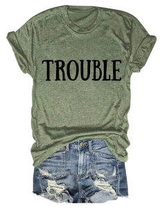 Dettaglio della t-shirt girocollo verde militare con stampa TROUBLE e shorts in denim
