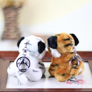 Close-up of yellow and white tiger plush keychains with metal lobster clasps