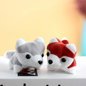 Close-up of plush husky puppy keychains in grey and red with soft fur and metal chains