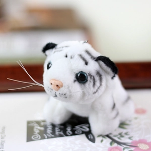 Detailed close-up of a white tiger cub plush keychain with soft fur and blue acrylic eyes