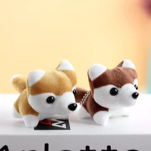 Close-up of cute plush husky dog keychains with metal chains on a white book