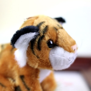 Close-up of cute tiger plush keychain with realistic fur texture and black stripes