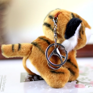 Detailed macro view of a plush tiger keychain with realistic stripes and metal lobster clasp