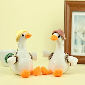 Close-up of cute plush duck keychain with mini hat detail and soft texture on warm background