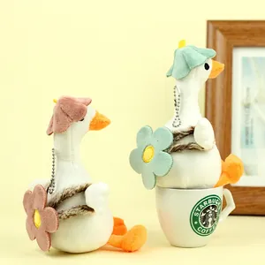 Detailed view of plush duck charms in pink and green colors on a yellow background