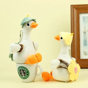 Close-up of cute plush duck keychains with colorful fisherman hats and a sunflower bag