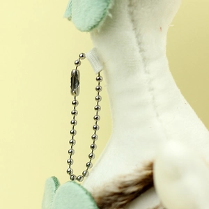 Detail of plush duck keychain with soft white fur and mint green felt accent