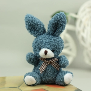 Close-up of blue plush bunny toy with long ears and brown checkered bowtie detail