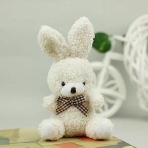 Close-up of white plush bunny with checkered bow tie showing soft teddy velvet texture