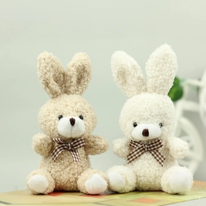 Detailed macro view of soft plush rabbit toys with checkered bows in brown and beige