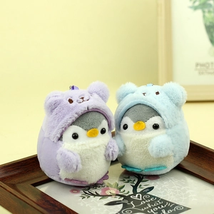 Dettaglio di morbidi ciondoli a pinguino in peluche con cappucci viola e blu