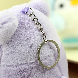 Dettaglio della chiusura a moschettone in metallo e portachiavi su peluche viola