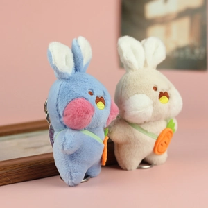 Dettaglio di portachiavi a forma di coniglio in peluche blu e beige con carote