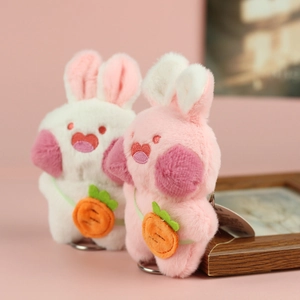Dettaglio portachiavi a forma di coniglio di peluche con borsa a carota bianca e rosa