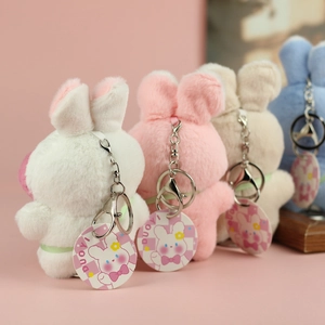 Dettaglio di quattro portachiavi a forma di coniglio in morbido peluche con gancio