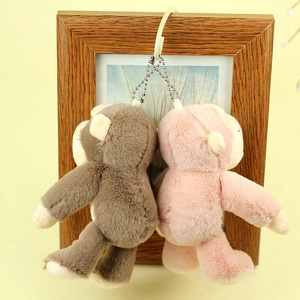Détail de porte-clés singes en peluche marron et rose avec fourrure douce et chaîne à perles