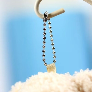 Detail of silver bead chain and ribbon attachment for plush teddy bear keychain