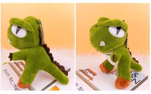 Close-up of a green dinosaur plush keychain with orange feet and soft texture for bags