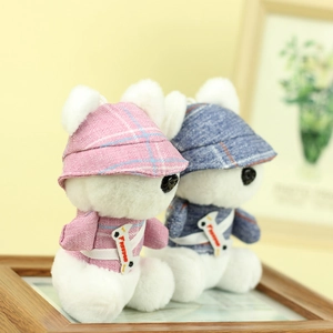 Close-up of plush bear keychains wearing pink and blue plaid outfits on a wooden frame