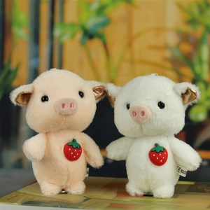 Close-up of plush pig charms with strawberry details and gold sequins on ears