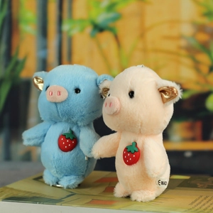 Detail of plush pig pendants with strawberry accents and golden sequin ears