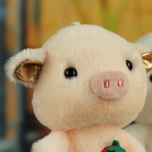 Close-up of cute pink plush pig with golden glitter ears and soft embroidered nose details