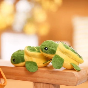 Close-up of cute green and yellow plush turtle charms with silver metal keychains