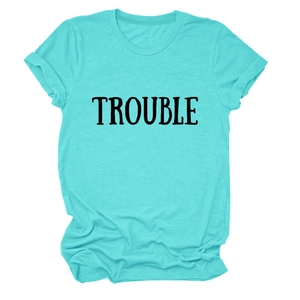 Dettaglio della t-shirt in cotone ciano con stampa TROUBLE nera e consistenza morbida