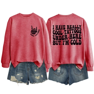 Flat lay of pink crewneck sweatshirt with slogan prints and ripped denim shorts