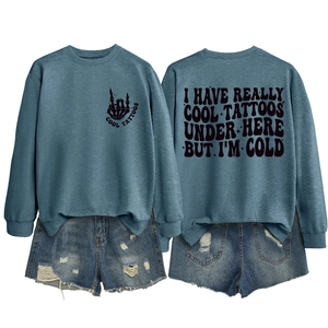 Flat lay of blue-grey sweatshirt with skull hand print and distressed denim shorts
