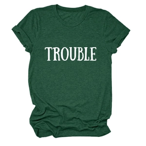 Dettaglio dei polsini arrotolati e della scritta TROUBLE sulla t-shirt verde scuro