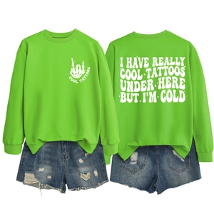 Front and back view of neon green sweatshirt with cool tattoos print and denim shorts