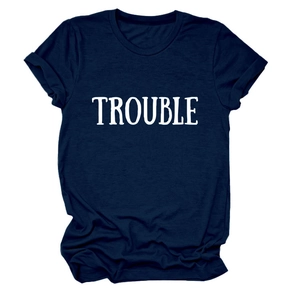 Dettaglio della scritta TROUBLE bianca su una t-shirt in cotone blu navy a girocollo