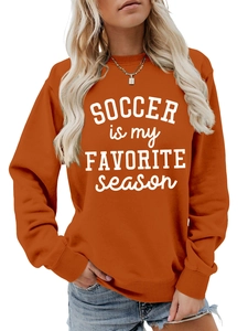 Detailansicht des gerippten Ausschnitts und Aufdrucks auf dem orangefarbenen Sweatshirt