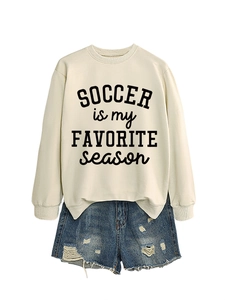 Cremefarbenes Fußball-Sweatshirt mit blauen Distressed-Denim-Shorts auf weißem Grund