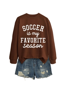 Detail eines kaffeebraunen Sweatshirts mit Fußball-Slogan und Denim-Shorts