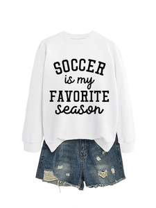 Detail eines weißen Fußball-Slogan-Sweatshirts mit distressed blauen Denim-Shorts