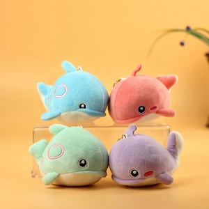 Cute plush whale pendants in four candy colors with metal keychains on a warm background
