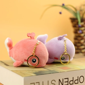 Plush whale keychain charms in pink and purple with heart spouts on gold rings