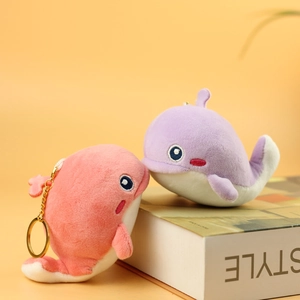 Close-up of cute pink and purple plush whale keychains with soft texture and golden metal rings