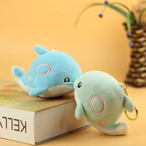 Detail of plush whale keychains in sky blue and mint green with golden metal rings