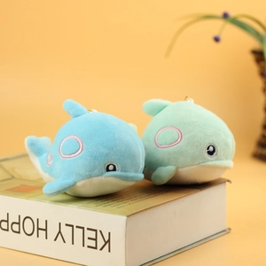 Close-up of blue and mint green plush dolphin pendants with gold metal keyrings