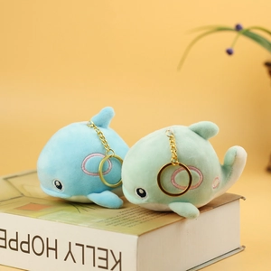 Detail of plush whale charms in blue and green with embroidery and golden chains