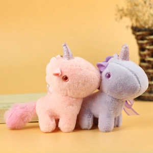 Close-up of pink and purple plush unicorn pendants with soft texture and glitter horns