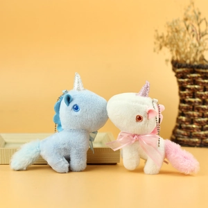 Detail of white and blue plush unicorn keychains with glitter horns and ribbon bows