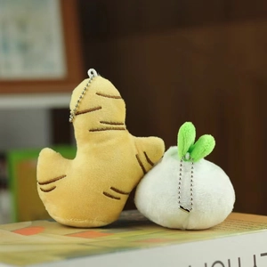 Cute plush ginger and garlic keychains with metal chains on a decorative book