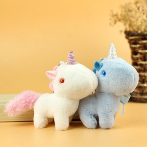 Detail of plush unicorn keychains in white and blue with sparkly horns and soft fur