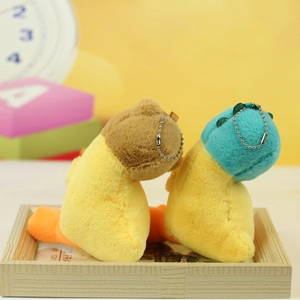 Detail of cute yellow plush duck charms with blue and brown heads on a wooden tray
